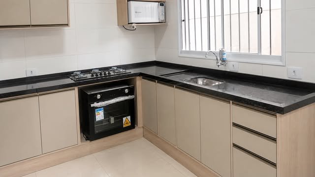 Cozinha com bancada escura e armários claros